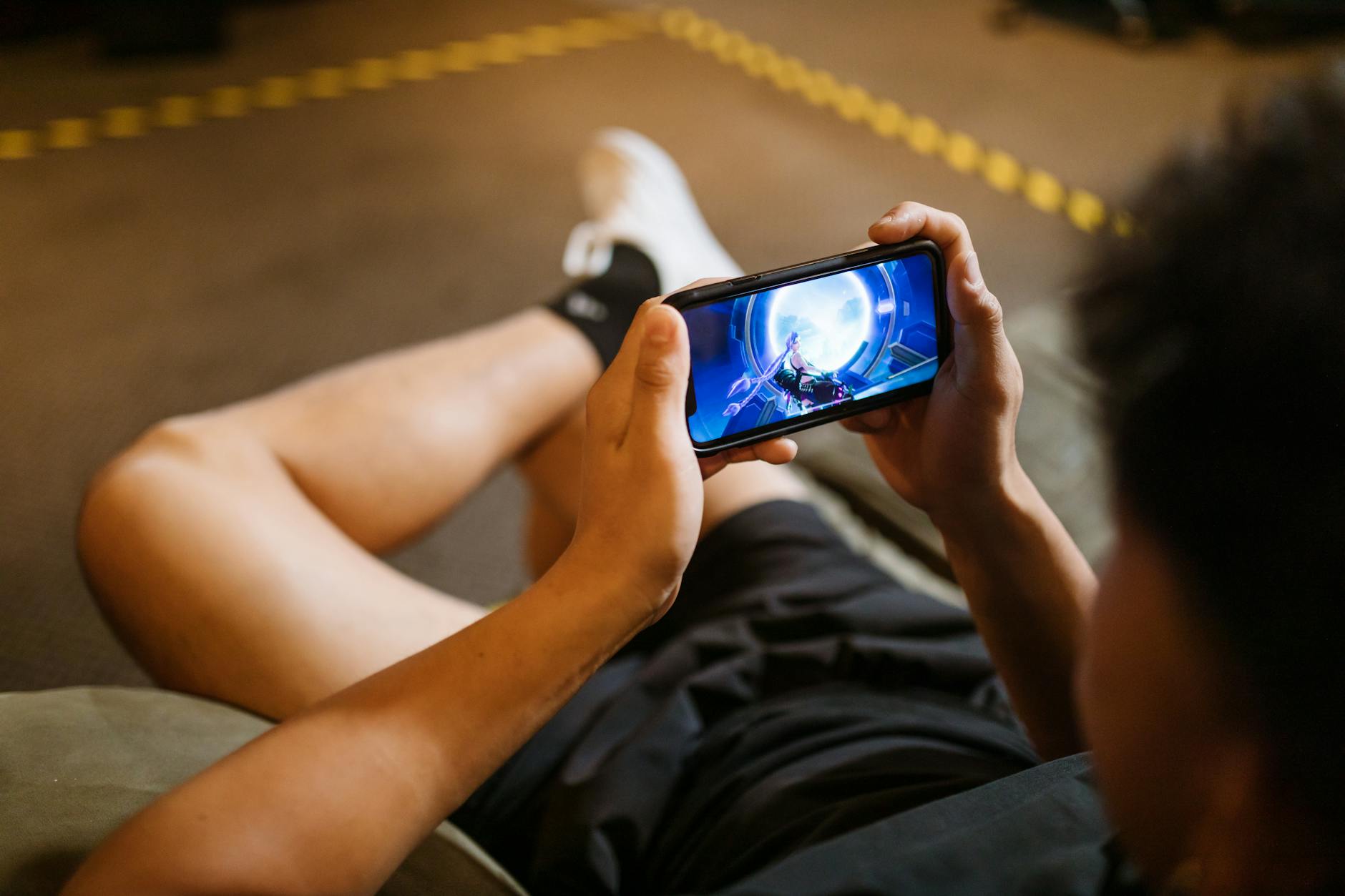 Người dùng cầm điện thoại chơi game trong điều kiện kết nối ổn định